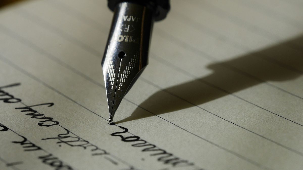 A pen and printed pages on a work surface, ready for signing.