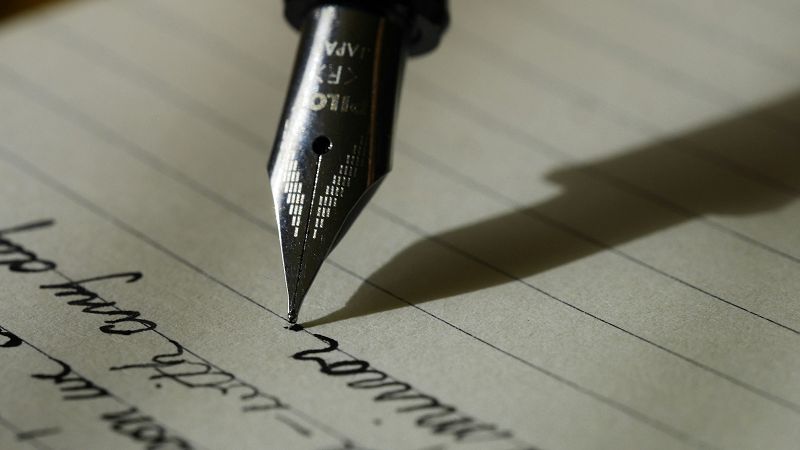 A pen and printed pages on a work surface, ready for signing.